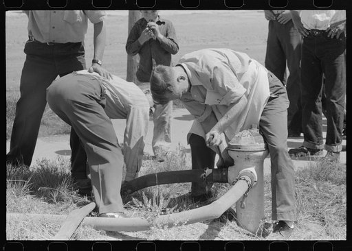 Connecting water hose at grass fire on Fourth of July. Vale, Oregon