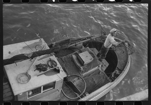 Throwing line ashore from fishing boat at the docks of the Columbia River Packing Association, Astoria, Oregon