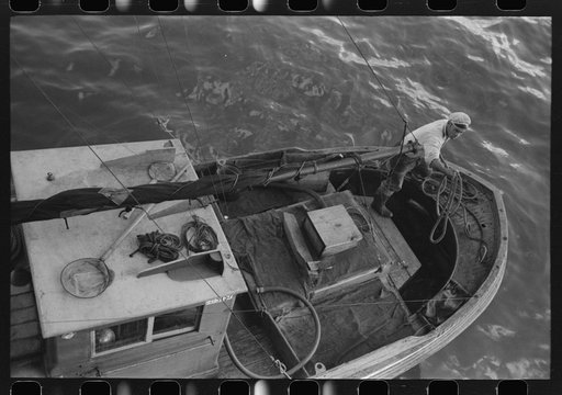 Throwing line ashore from fishing boat at the docks of the Columbia River Packing Association, Astoria, Oregon