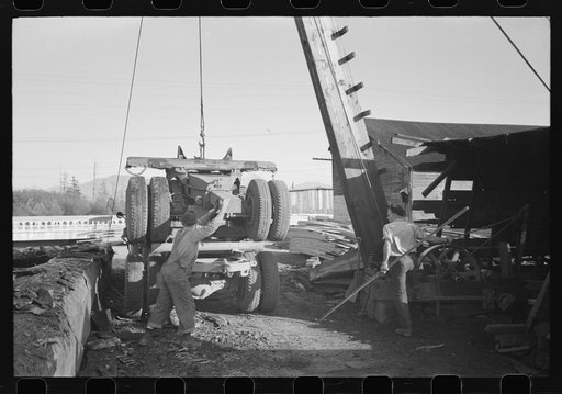 Loading onto trailer truck, logging operations, Tillamook County, Oregon. The trailer is carried on the truck when it returns to the woods empty for more logs