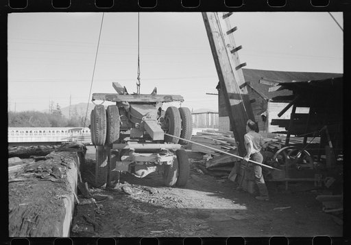 Untitled photo, possibly related to: Loading onto trailer truck, logging operations, Tillamook County, Oregon. The trailer is carried on the truck when it returns to the woods empty for more logs