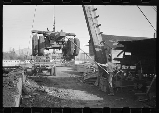 Loading onto trailer truck, logging operations, Tillamook County, Oregon. The trailer is carried on the truck when it returns to the woods empty for more logs