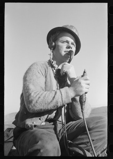 Signal man at Shasta Dam, Shasta County, California. He telephones to crew at central tower and instructs them how to handle buckets of concrete, etc.