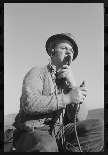 Untitled photo, possibly related to: Signal man at Shasta Dam, Shasta County, California. He telephones to crew at central tower and instructs them how to handle buckets of concrete, etc.