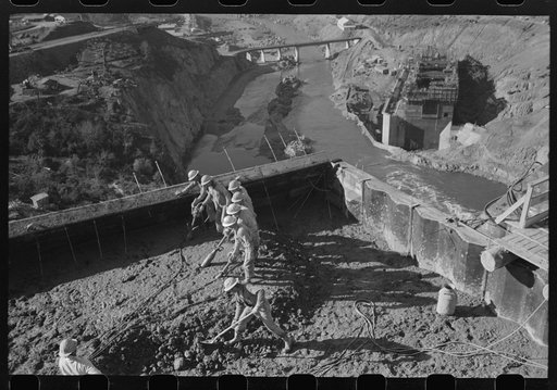 Workmen using viberators which spread the wet concrete in construction of Shasta Dam, Shasta County, California