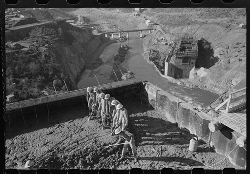 Workmen using viberators which spread the wet concrete in construction of Shasta Dam, Shasta County, California