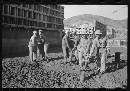 Workmen using viberators which spread the wet concrete in construction of Shasta Dam, Shasta County, California
