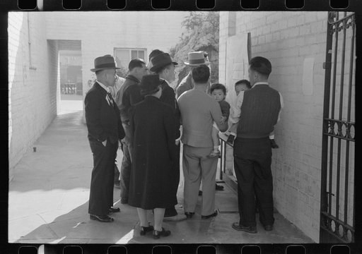 Los Angeles, California. Japanese-American evacuation from West Coast areas under U.S. Army war emergency order. Reading evacuation orders on bulletin board at Maryknoll mission