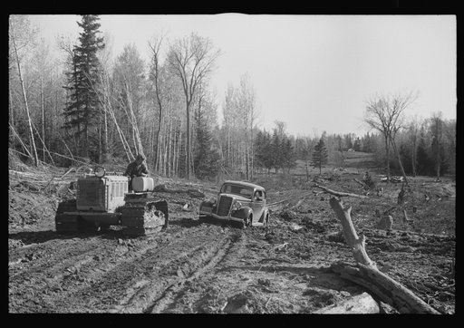 FSA (Farm Security Administration) photographer being pulled out of mud by tractor, near Littlefork, Minnesota