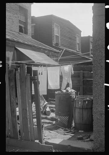 Washington, D.C. An ugly backyard littered with rubbish, showing part of a washing on the clothesline