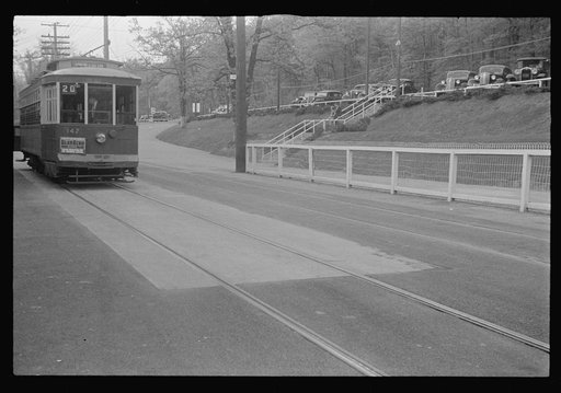 Glen Echo, Maryland. A general view near Glen Echo Park showing a street car with a Glen Echo advertisement on the front headed for Union Station, and parked cars on the road above
