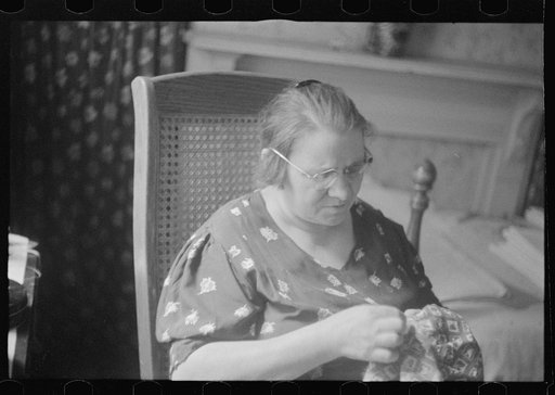 Washington, D.C. A woman doing handwork in her bedroom