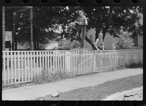 Untitled photo, possibly related to: Boys walking fence. Washington, Indiana