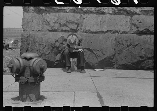 Man seated on corner of Jefferson Street and Vernon Park Place, Chicago, Illinois