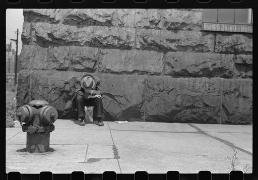 Man seated on corner of Jefferson Street and Vernon Park Place, Chicago, Illinois