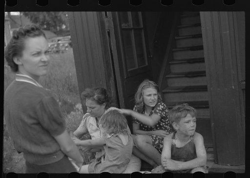 Untitled photo, possibly related to: People sitting on steps in front of apartment. Superior, Wisconsin