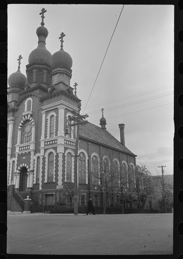 Untitled photo, possibly related to Mount Carmel, Pennsylvania. A brick church building with white stone trimming, towers, and a triple cross