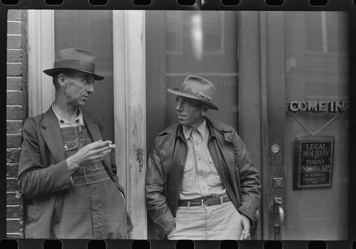 Two farmers talking outside of a main street bank, Roxboro, North Carolina, Memorial Day