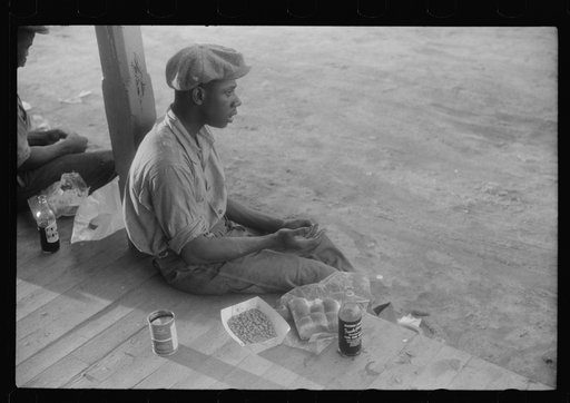 Florida migrant having supper consisting of cold baked beans, bread, and a bottle of pop. Belcross, North Carolina