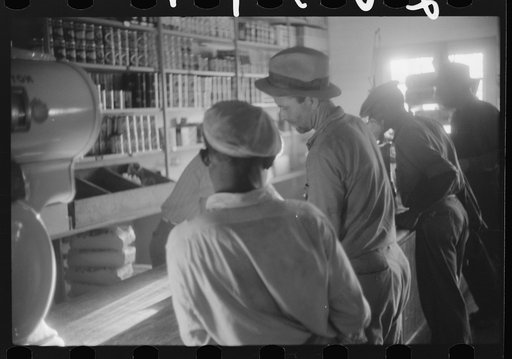 Migratory agricultural workers buying canned goods for supper at the company store. Belcross, North Carolina