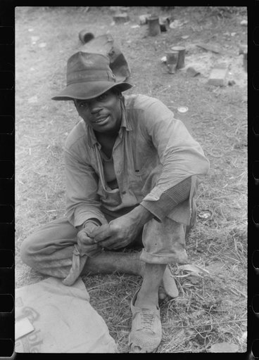 Florida migratory agricultural worker, playing cards during lunch hour at the Belcross, North Carolina grading station.
