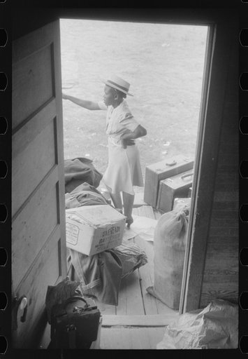 Florida migrant with luggage waiting to leave Belcross, North Carolina for another job at Onley, Virginia