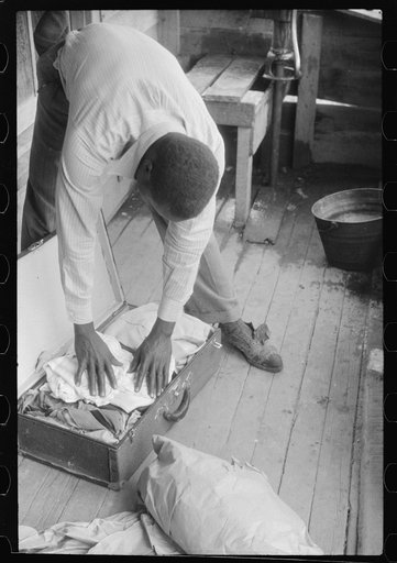Untitled photo, possibly related to: Migrant packing his bag for a trip from Belcross, North Carolina to another job at Onley, Virgin