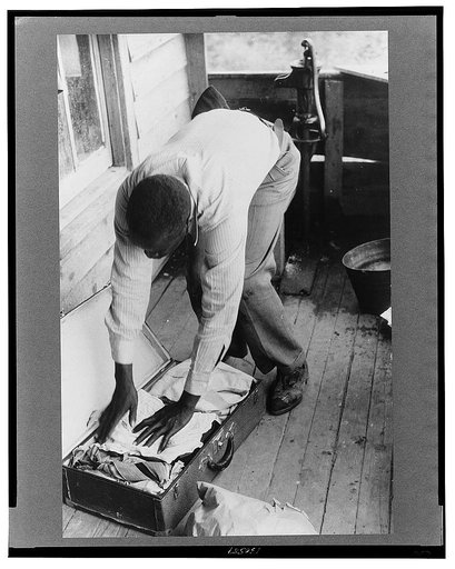 Migrant packing his bag for a trip from Belcross, North Carolina to another job at Onley, Virgin