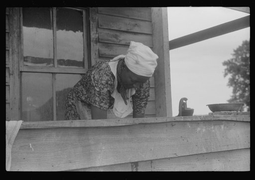 Migratory workers from Georgia washing clothes. Thirty-five people stay in this house. Near Belcross, North Carolina