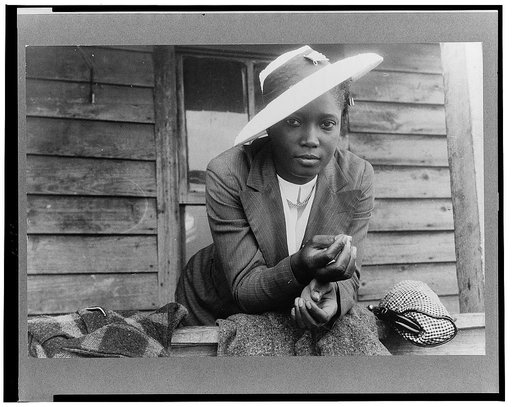 Migratory agricultural worker from Florida waiting to leave Belcross, North Carolina to another job at Onley, Virginia. It is Sunday and she is wearing her best clothes