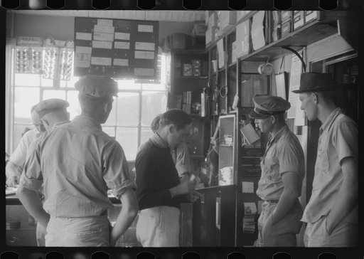 Untitled photo, possibly related to: Truck driver in front of bulletin board in a truck service station on U.S. 1 (New York Avenue) in Washington, D.C.