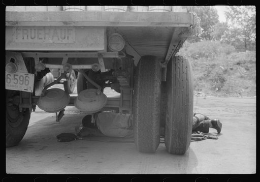 Negro driver asleep under a truck. There are no sleeping accomodations for Negroes at this service station. On U.S. 1