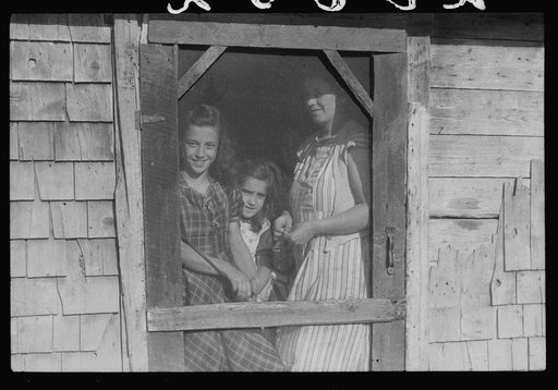 Mrs. Patrick Dumond and two of her children at back door of their home in Lille, Maine. French-Canadian potato farmer and FSA (Farm Security Administration) clients