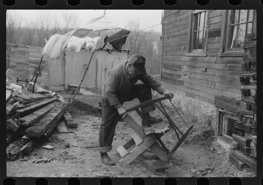 Old man, French Canadian, who worked in a paper mill for eleven years, in front of his house sawing wood, Montville, Connecticut