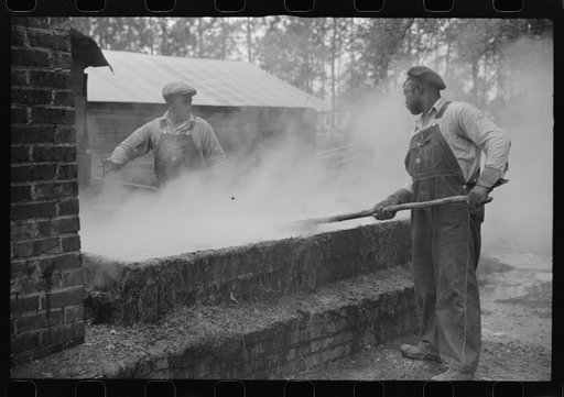 Untitled photo, possibly related to: Cleaning turpentine cups in boiling water at a still near Pembroke, Georgia