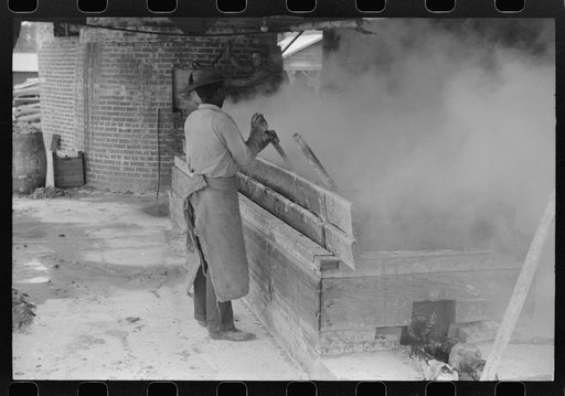 Untitled photo, possibly related to: Filtering hot rosin through sieves at a turpentine works in Statesboro, Georgia