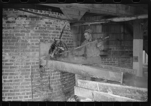 Tapping the furnace of hot rosin at a turpentine works in Statesboro, Georgoa