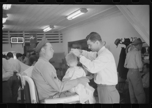 Untitled photo, possibly related to: Sergeant from Fort Benning getting his son's hair cut at a barber shop in Columbus, Georgia