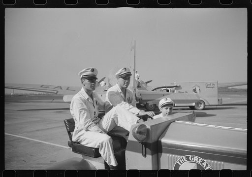 Washington, D.C. Workers at the municipal airport riding a little truck used to haul baggage and freight around the field