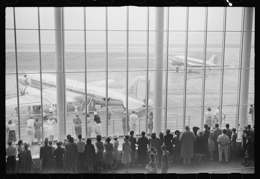 Visitors watching planes through the window of the main waiting room at the municipal airport in Washington, D.C.
