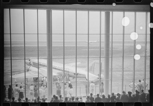 Untitled photo, possibly related to: Visitors watching planes through the window of the main waiting room at the municipal airport in Washington, D.C.