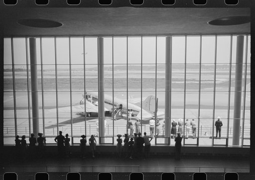 Visitors watching planes through the window of the main waiting room at the municipal airport in Washington, D.C.