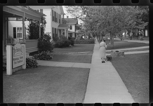Untitled photo, possibly related to: Old woman and Pekingese walking along a street in Saint Albans, Vermont