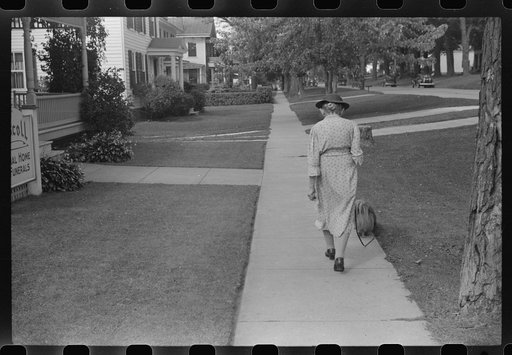 Untitled photo, possibly related to: Old woman and Pekingese walking along a street in Saint Albans, Vermont