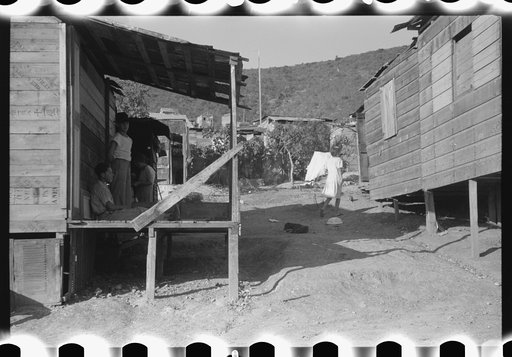 Untitled photo, possibly related to: Street in slum area in Ponce, Puerto Rico. The land on which the houses stand rented from between eighty cents and a dollar a lot per month. Each person built his own house. They had to pay twenty cents per month for water