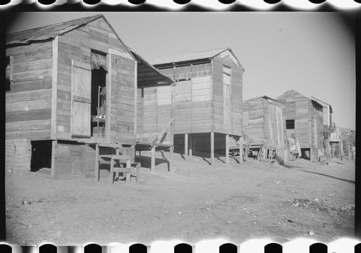 Untitled photo, possibly related to: Street in slum area in Ponce, Puerto Rico. The land on which the houses stand rented from between eighty cents and a dollar a lot per month. Each person built his own house. They had to pay twenty cents per month for water