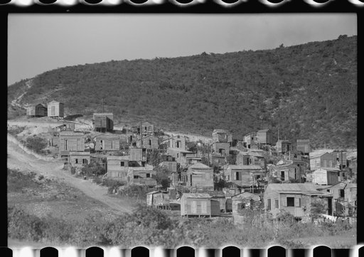 Untitled photo, possibly related to: Street in slum area in Ponce, Puerto Rico. The land on which the houses stand rented from between eighty cents and a dollar a lot per month. Each person built his own house. They had to pay twenty cents per month for water