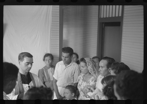 Priest baptizing children at the celebration for tenant purchase FSA (Farm Security Administration) borrowers on a farm near Corozal, Puerto Rico