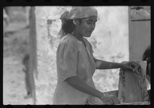 Untitled photo, possibly related to: Puerto Rican woman washing clothes in one of the slum "villages" near Fredericksted, St. Croix, Virgin Islands
