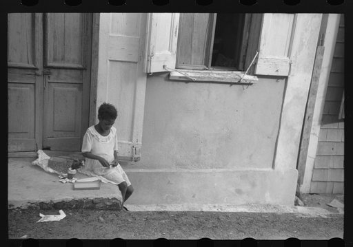 Little girl playing with her Christmas presents on a side street in Charlotte Amalie, Virgin Islands